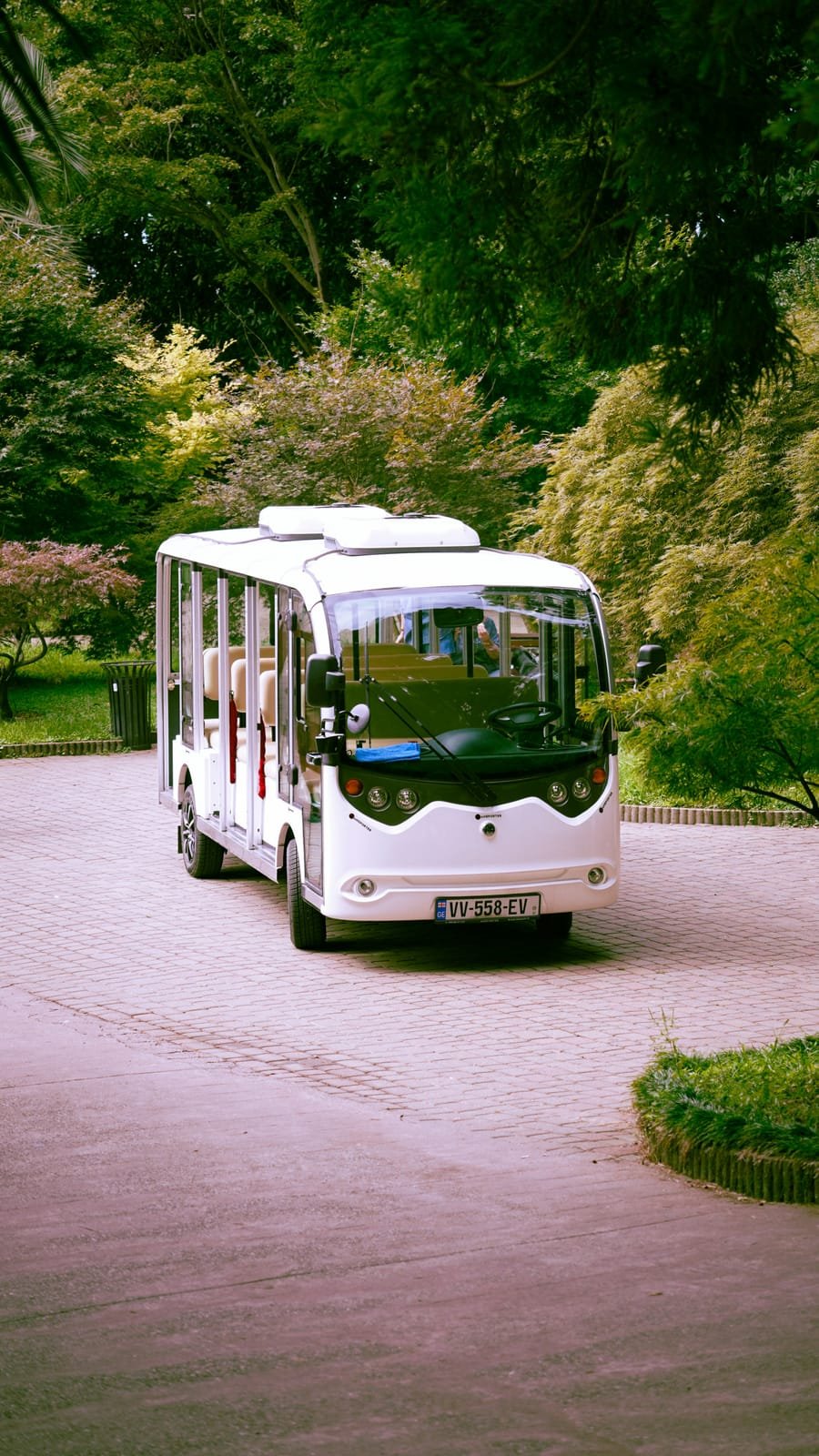 Electric shuttle vehicle on a resort path lined with trees